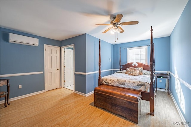 bedroom featuring light hardwood / wood-style flooring, an AC wall unit, and ceiling fan