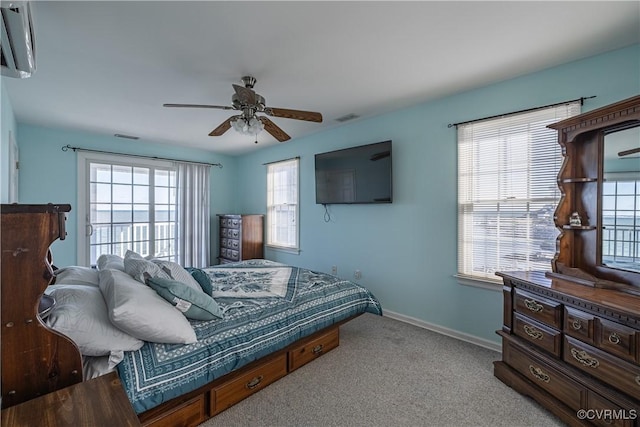 bedroom featuring light colored carpet, multiple windows, and ceiling fan