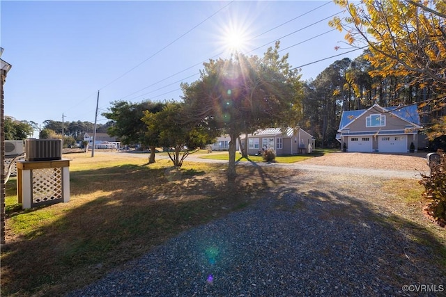 view of yard featuring a garage and central AC