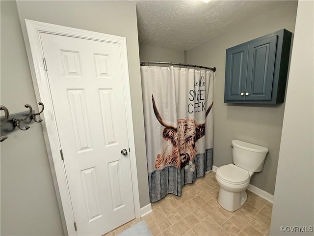 bathroom with curtained shower, a textured ceiling, and toilet