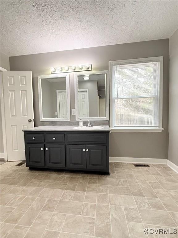 bathroom with vanity and a textured ceiling