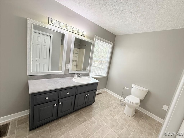 bathroom with vanity, a textured ceiling, and toilet