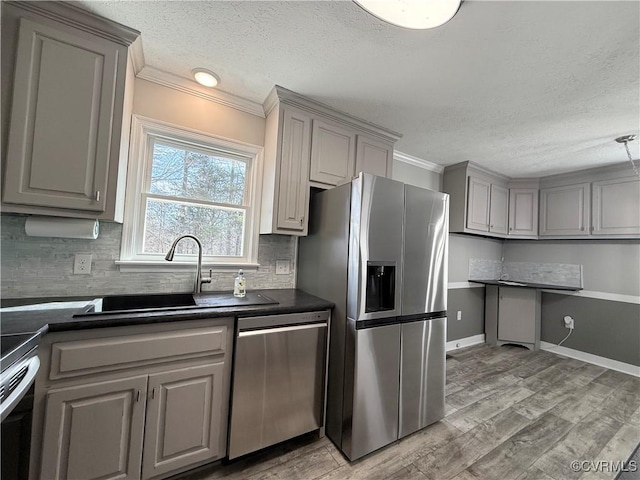 kitchen featuring stainless steel appliances, gray cabinets, and light hardwood / wood-style flooring