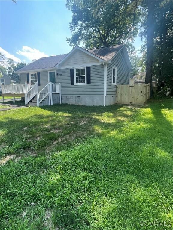 rear view of house featuring a yard and a wooden deck