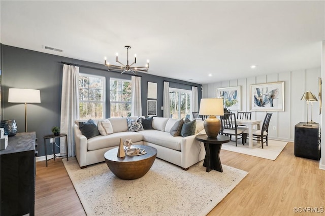 living room featuring an inviting chandelier and light hardwood / wood-style floors