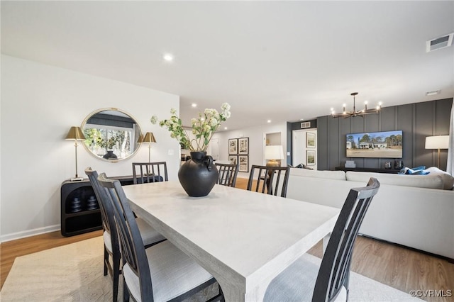 dining room featuring an inviting chandelier and light hardwood / wood-style flooring