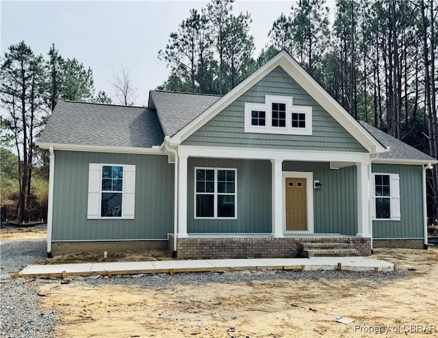 view of front of house featuring roof with shingles and a porch