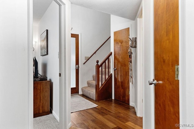 foyer with light wood-type flooring and a textured ceiling