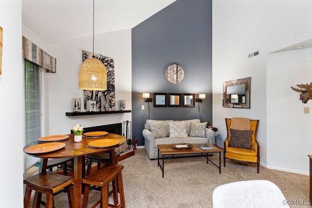 living room featuring a towering ceiling and light carpet