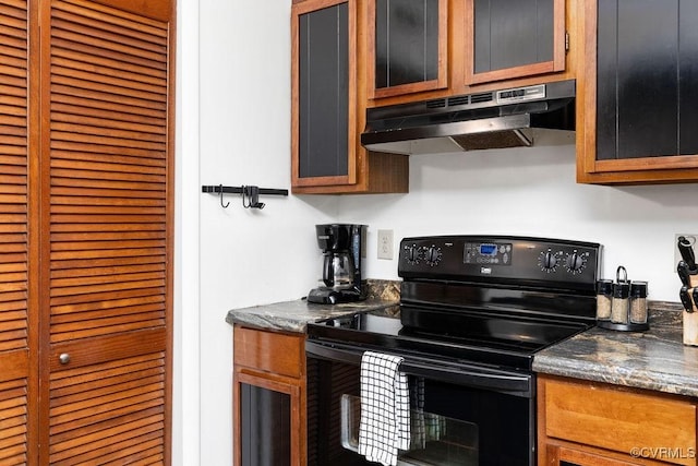 kitchen with black electric range oven and dark stone countertops