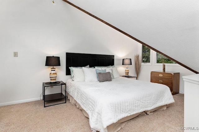 bedroom featuring light colored carpet and vaulted ceiling