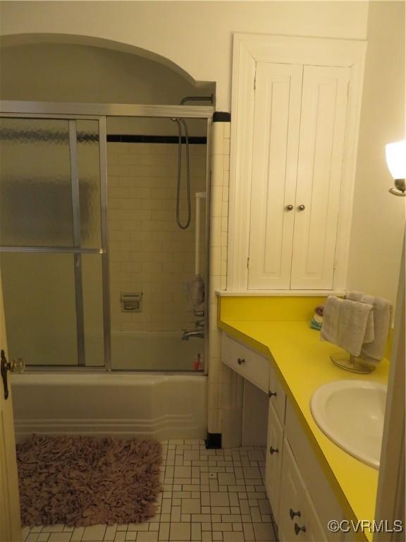 bathroom with tile patterned flooring, vanity, and tiled shower / bath combo