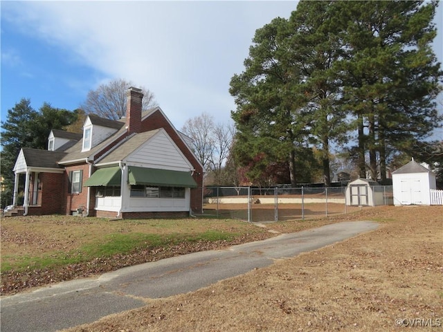 view of side of home with a storage shed