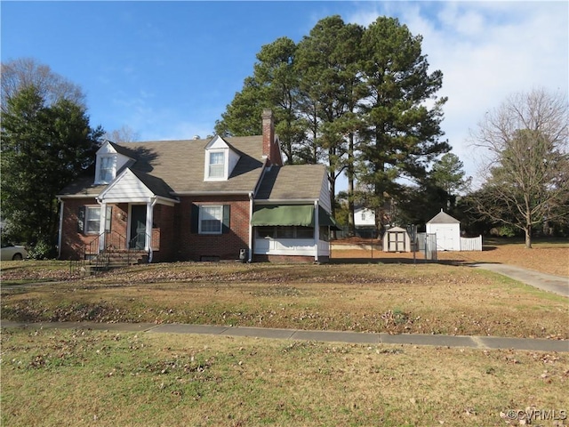 view of front of house with a shed and a front yard