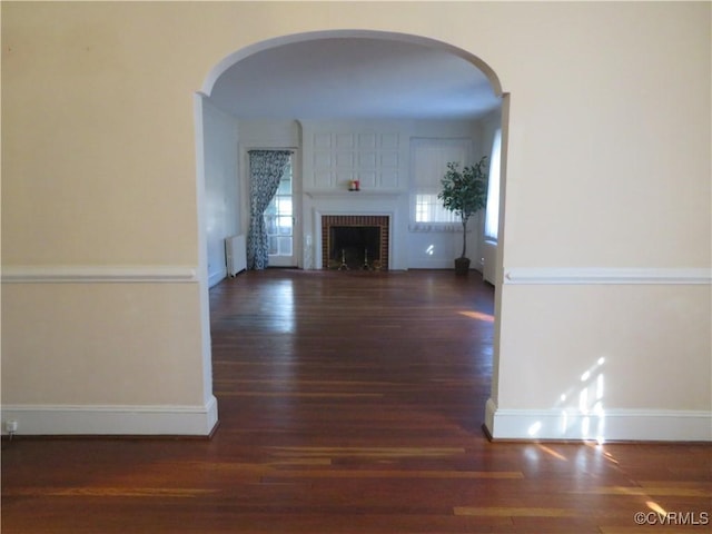 unfurnished living room with dark hardwood / wood-style floors and a fireplace