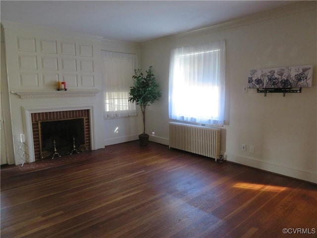 unfurnished living room featuring dark hardwood / wood-style flooring, radiator heating unit, a fireplace, and ornamental molding