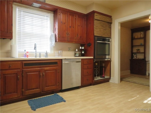 kitchen with light hardwood / wood-style floors, sink, and stainless steel appliances