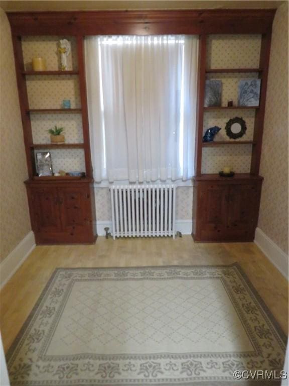 interior space with radiator heating unit and light hardwood / wood-style flooring