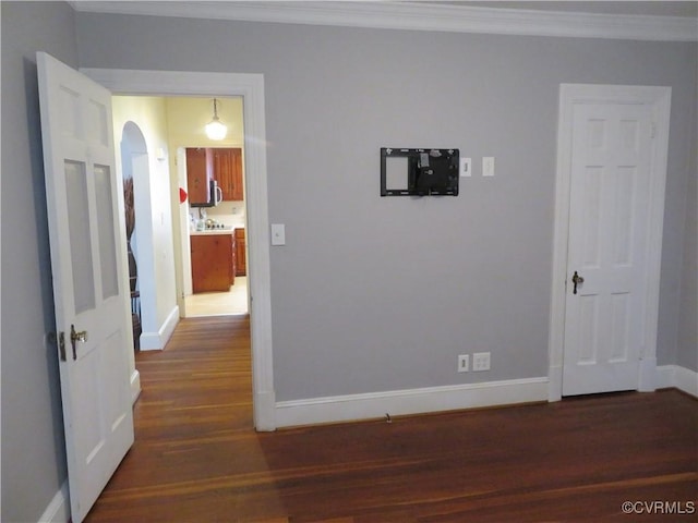 corridor featuring ornamental molding and dark wood-type flooring