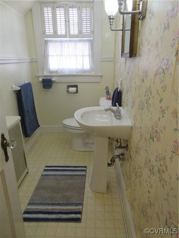 bathroom with tile patterned floors, toilet, and radiator heating unit