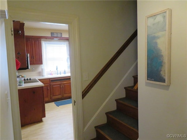 stairs with hardwood / wood-style floors and sink