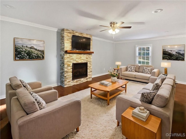 living room featuring wood-type flooring, a stone fireplace, ceiling fan, and crown molding