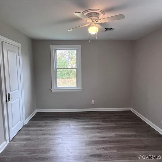 spare room featuring ceiling fan and dark wood-type flooring