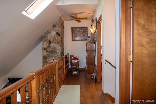 hallway with lofted ceiling with skylight and dark wood-type flooring