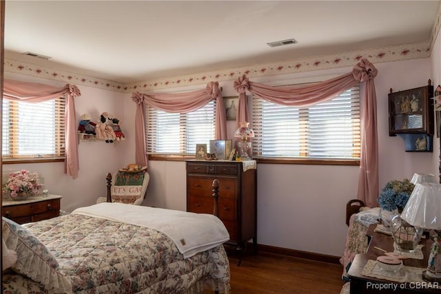 bedroom with hardwood / wood-style flooring and multiple windows