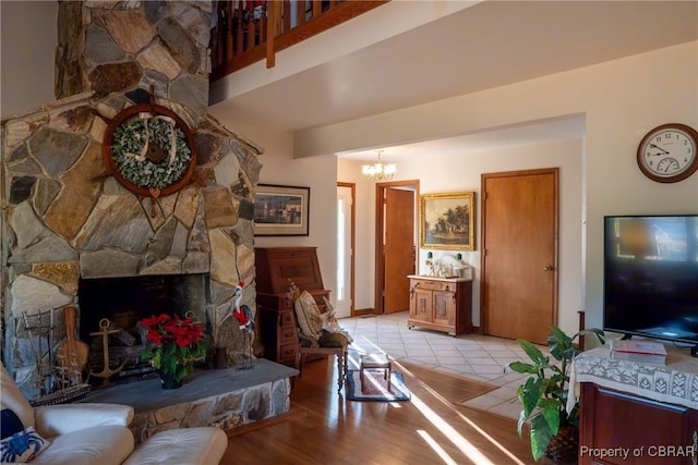 living room with a notable chandelier, light hardwood / wood-style floors, and a fireplace