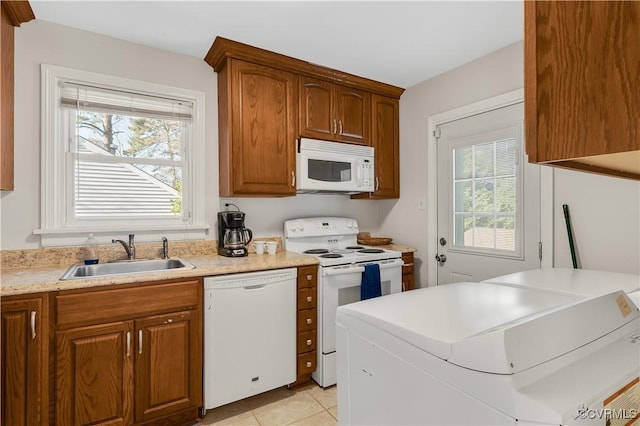 kitchen with white appliances, a healthy amount of sunlight, sink, and light tile patterned floors