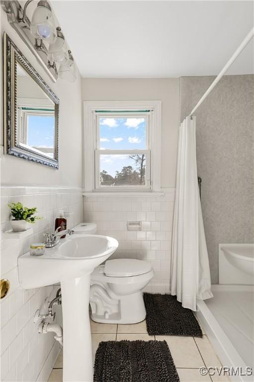 bathroom with tile walls, a shower with shower curtain, tile patterned floors, and toilet