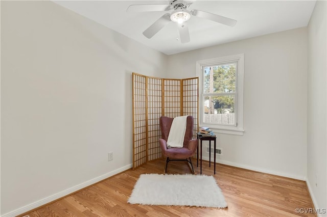 living area with light wood-type flooring and ceiling fan