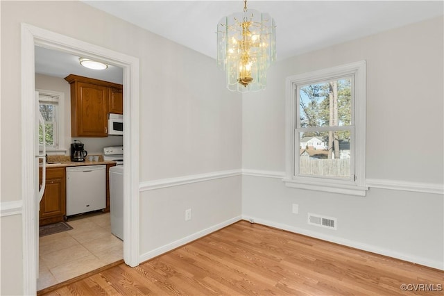 dining space featuring light hardwood / wood-style flooring and an inviting chandelier