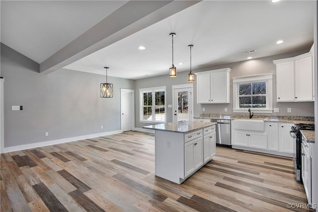 kitchen with a kitchen island, white cabinetry, hanging light fixtures, light stone countertops, and appliances with stainless steel finishes