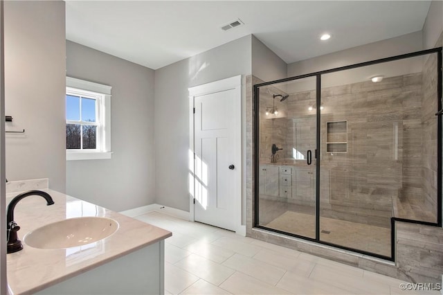 bathroom featuring a shower with door and vanity