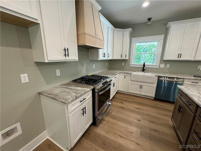 kitchen with sink, white cabinets, appliances with stainless steel finishes, and custom exhaust hood