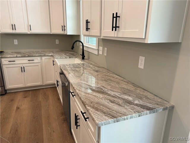 kitchen featuring light stone countertops, sink, white cabinetry, and hardwood / wood-style flooring