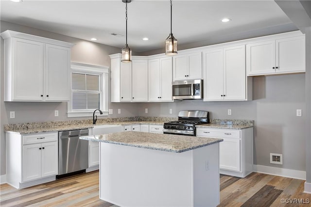 kitchen with white cabinets, appliances with stainless steel finishes, and a kitchen island