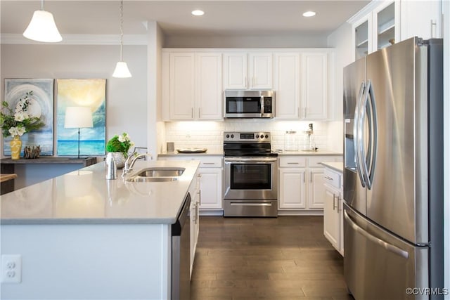 kitchen featuring appliances with stainless steel finishes, dark wood-type flooring, sink, decorative light fixtures, and white cabinetry