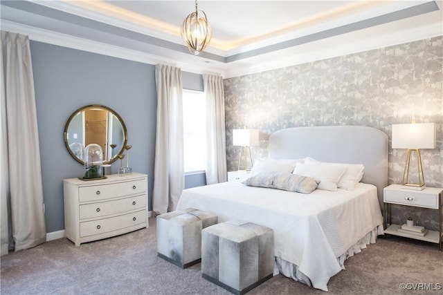 carpeted bedroom with a tray ceiling and crown molding