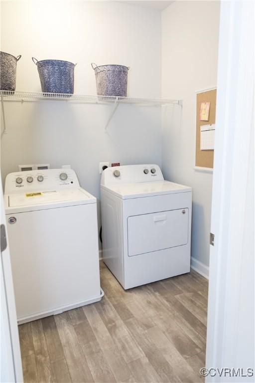 laundry area featuring light hardwood / wood-style flooring and washing machine and clothes dryer