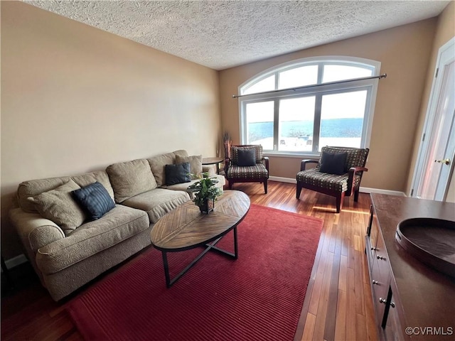 living room with a water view, a textured ceiling, and hardwood / wood-style flooring