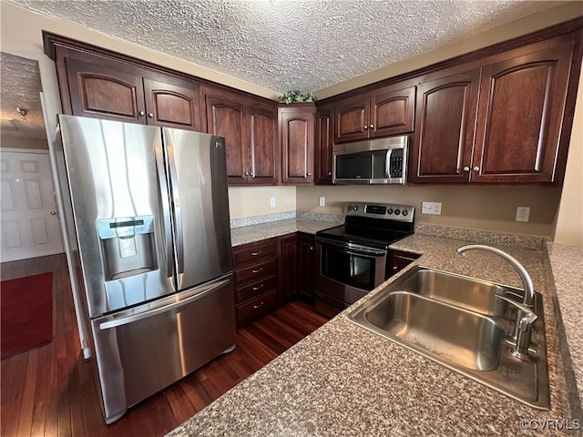 kitchen featuring a textured ceiling, sink, dark hardwood / wood-style floors, and appliances with stainless steel finishes