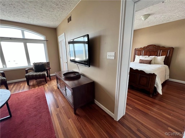 bedroom with a textured ceiling and dark wood-type flooring