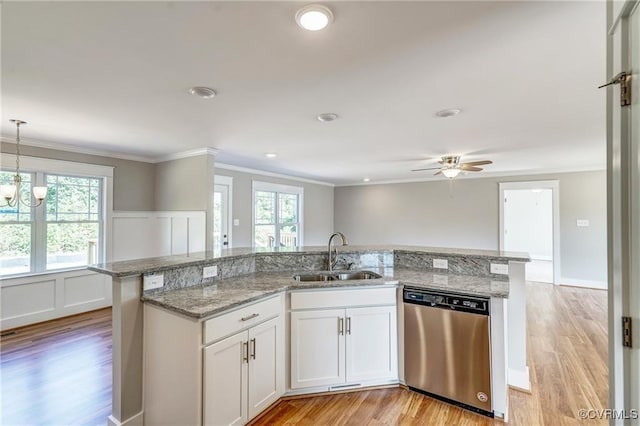 kitchen featuring dishwasher, sink, hanging light fixtures, light hardwood / wood-style flooring, and white cabinets