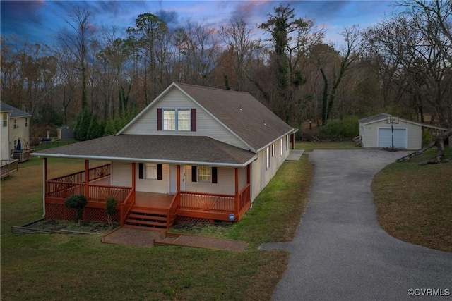 country-style home featuring a yard, covered porch, an outdoor structure, and a garage