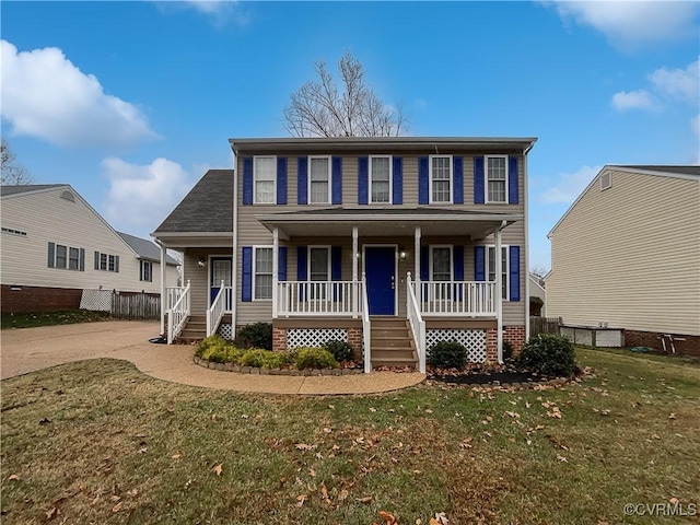 colonial home featuring a porch and a front lawn