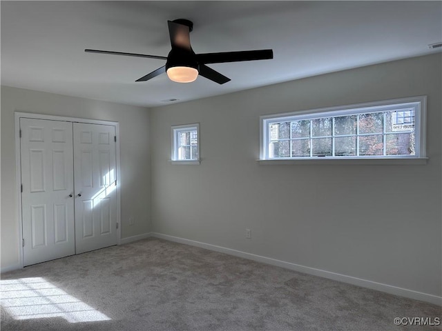 interior space with ceiling fan and light colored carpet