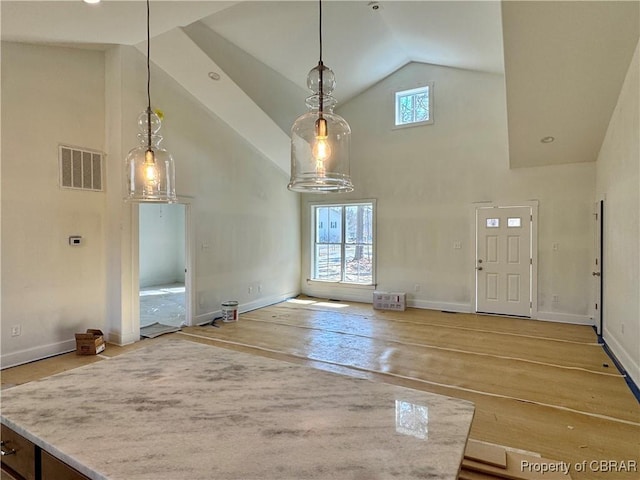 interior space featuring visible vents, high vaulted ceiling, baseboards, and hardwood / wood-style floors